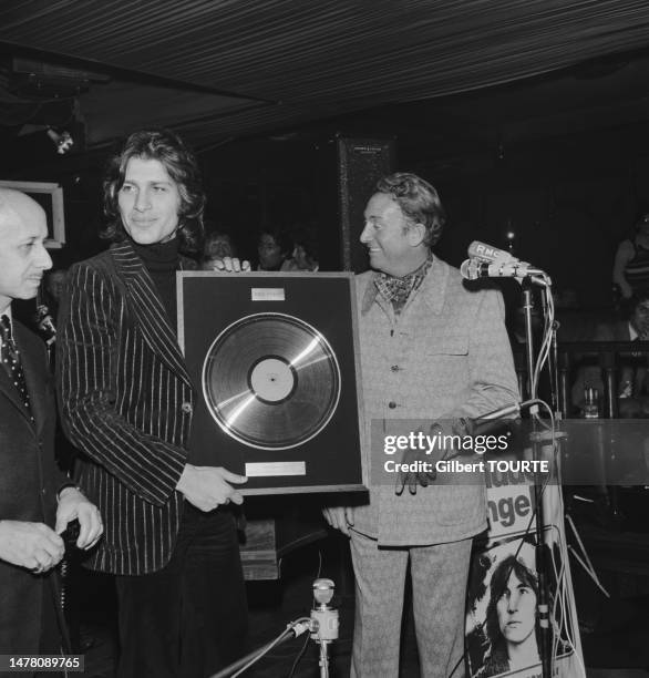 Charles Trenet remet un disque d'or à Mike Brant au Whisky a GoGo lors du salon du Midem à Cannes en janvier 1973