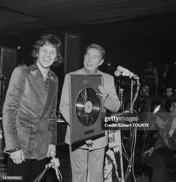 Charles Trenet remet un disque d'or à Gérard Lenorman au Whisky a GoGo lors du salon du Midem à Cannes en janvier 1973