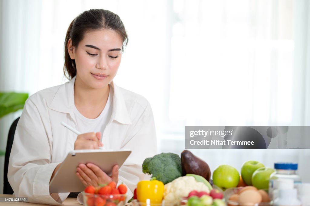 Obesity Can Diminish the Overall Quality of Life and You Can Do on Nutrition Plan Ahead. Female nutritionists examine and prepare a diet plan for patients of obesity via a mobile app on a tablet computer.