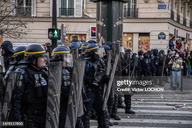 Cordon de police anti émeute se protégeant avec leurs boucliers lors de la manifestation contre la réforme allongeant l'âge de départ à la retraite à...