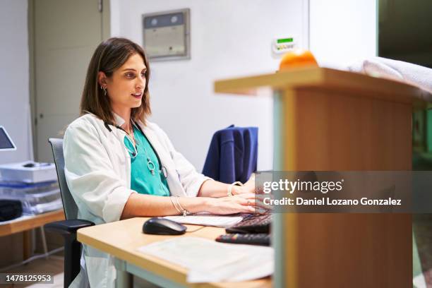 doctor working with a computer in a hospital office - public service stock pictures, royalty-free photos & images