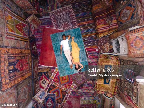 drone view of couple lying on carpet and surrounded by carpets - cappadocië stockfoto's en -beelden