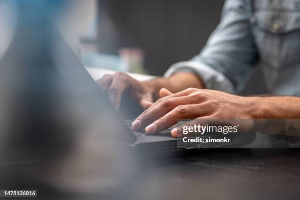 mans manos utilizando una computadora portátil - typing fotografías e imágenes de stock