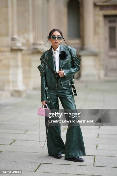 Gabriella Berdugo wears blue and yellow print pattern logo sunglasses from Moschino, gold and silver earrings, necklaces, a white cropped ripped...