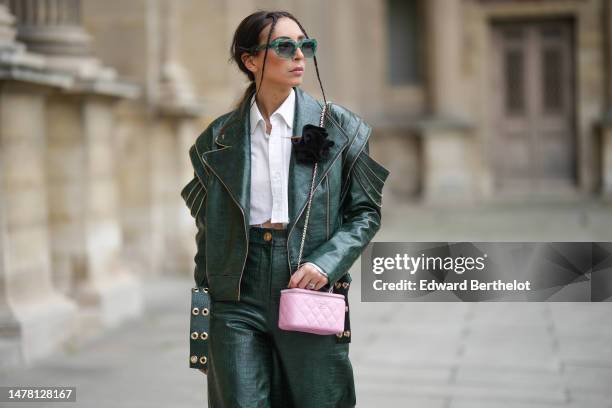 Gabriella Berdugo wears blue and yellow print pattern logo sunglasses from Moschino, gold and silver earrings, necklaces, a white cropped ripped...