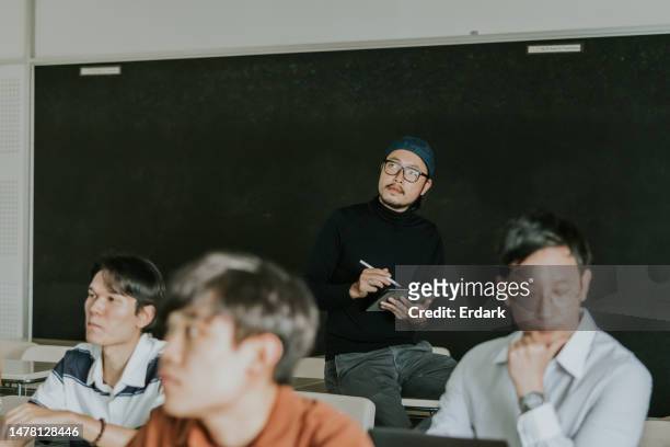 professeur de design asiatique regardant et écoutant son travail de présentation étudiant. - master class photos et images de collection