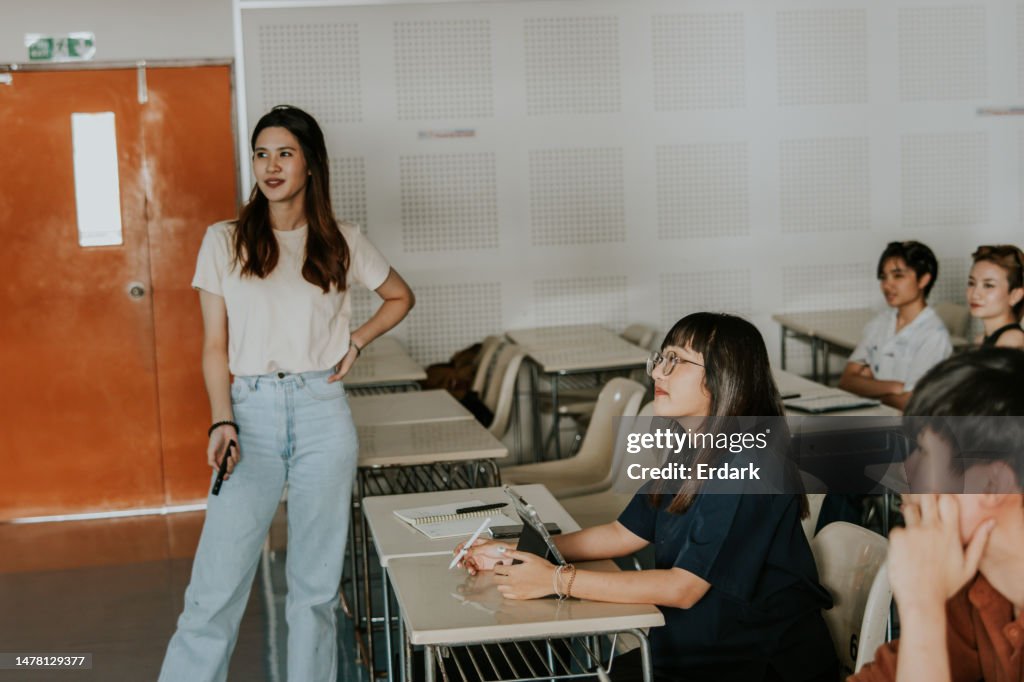 Hermosa estudiante de arquitectura asiática de pie frente a clase y presenta su diseño de proyecto de trabajo de estudio de caso con pasión y confianza.