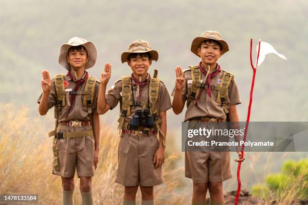 asian three scout students stand and display the scout symbols in the scout camp. - scouts honour stock pictures, royalty-free photos & images