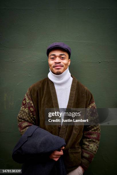 fashionable man standing against a green wall - lambert stock pictures, royalty-free photos & images