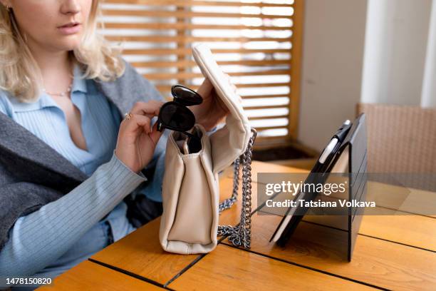 cropped shot of a woman taking sunglasses out of her bag - internal stock pictures, royalty-free photos & images