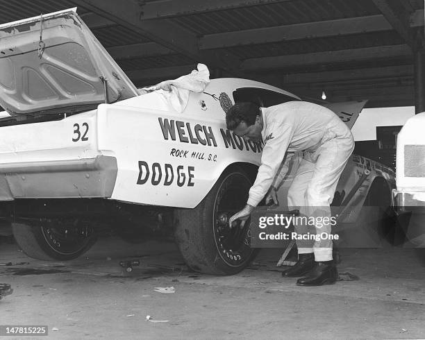 October 1968: Driver Marty Robbins helps change a tire on his Dick Behling-owned 1967 Dodge Charger during practice for the National 500 NASCAR Cup...