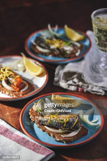 poisson en conserve - sardines aux oignons et citron sur pain brun - sardine photos et images de collection