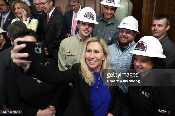 Rep. Marjorie Taylor Greene takes a selfie with energy workers from Encino Energy company prior to a news conference after the vote for H.R.1 – Lower...