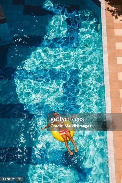 boy enjoys the summer in swimming pool - boy pool float stock pictures, royalty-free photos & images