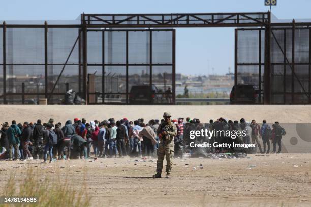 Migrants who crossed the border trough the Rio Bravo from Mexico into the U.S. Wait next to the U.S. Border wall where U.S. Border Patrol agents...