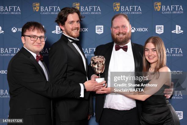 Sam McGarry, a guest, Adam Goodchild and Beth Molloy, from Poncle Studio with the Best Game Award for 'Vampire Survivors' during the 2023 BAFTA Games...