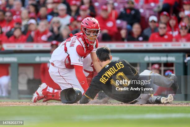 Tyler Stephenson of the Cincinnati Reds tags out Bryan Reynolds of the Pittsburgh Pirates at home plate on Opening Day at Great American Ball Park on...