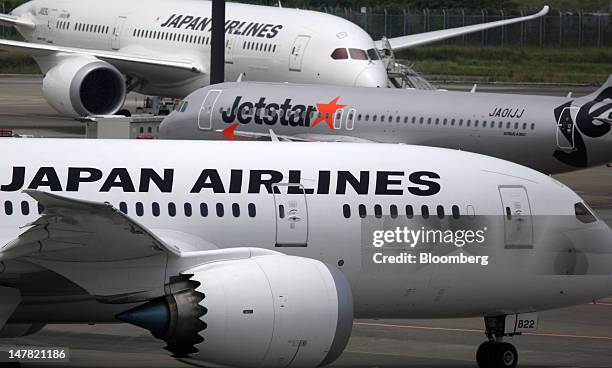 Jetstar Japan Co. Aircraft, center, taxies near two Japan Airlines Co. Aircraft at Narita Airport in Narita City, Chiba Prefecture, Japan, on...