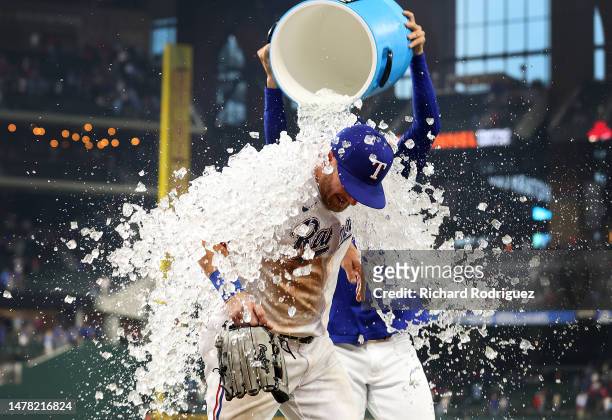 Robbie Grossman of the Texas Rangers is doused with sports drink by Martin Perez after an 11-7 win over the Philadelphia Phillies on Opening Day at...