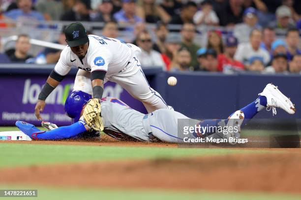 Brandon Nimmo of the New York Mets slides safely into third base against Jean Segura of the Miami Marlins during the sixth inning on Opening Day at...