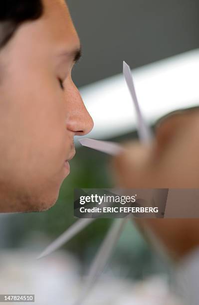 Student from Brazil, smells a fragrance melt on test strips in a laboratory at the Givaudan Perfumery School on July 4, 2012 in Argenteuil, northern...