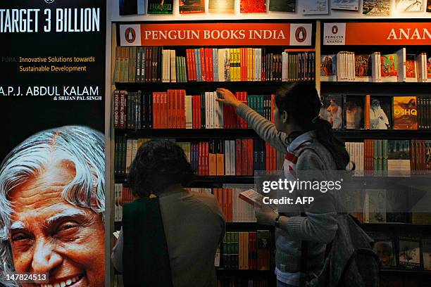 Indian women browse through Penguin edition books on display at the New Delhi World Book Fair in New Delhi on February 25, 2012. The 20th edition of...