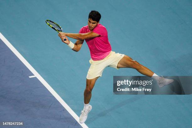 Carlos Alcaraz of Spain hits a backhand against Taylor Fritz of the United States in the quarter-finals of the men's singles at the Miami Open at the...