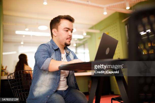 focused man typing on his laptop at work - little people stock pictures, royalty-free photos & images