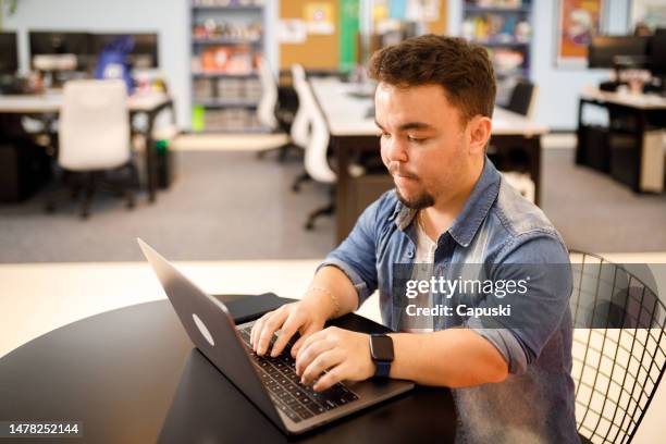 man typing on his laptop at work - dwarf man bildbanksfoton och bilder