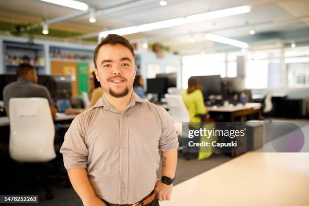 glücklicher mann im büro, der in die kamera lächelt - dwarf stock-fotos und bilder