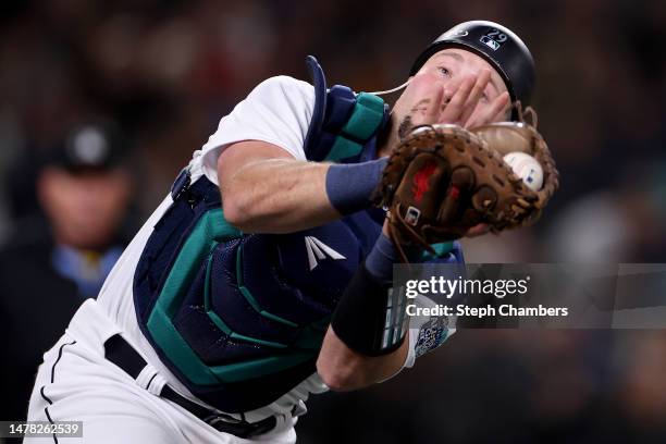 Cal Raleigh of the Seattle Mariners catches a foul ball during the sixth inning against the Cleveland Guardians during Opening Day at T-Mobile Park...