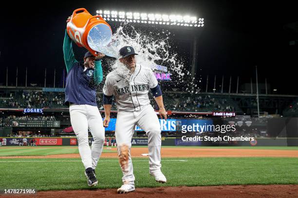 Tom Murphy douses Ty France of the Seattle Mariners after their 3-0 win against the Cleveland Guardians during Opening Day at T-Mobile Park on March...