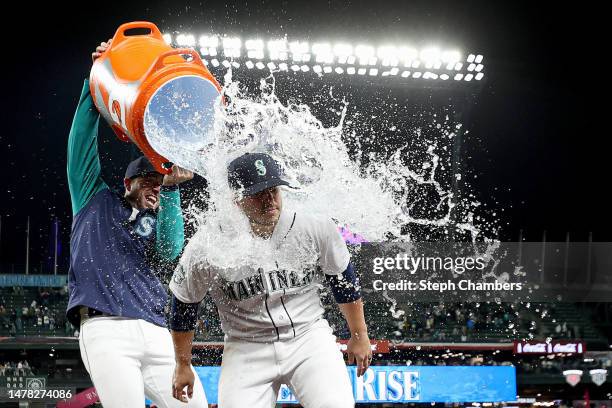 Tom Murphy douses Ty France of the Seattle Mariners after their 3-0 win against the Cleveland Guardians during Opening Day at T-Mobile Park on March...