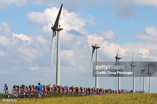 The peloton passes by windmills during stage four of the 2012 Tour de France from Abbeville to Rouen on July 4, 2012 in Veules-les-Roses, France.