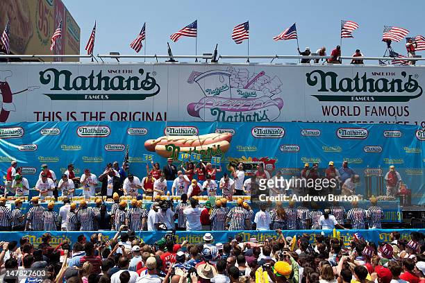 Competitive eaters compete in the men's division of the Nathan's Famous International Hot Dog Eating Contest at Coney Island on July 4, 2012 in the...