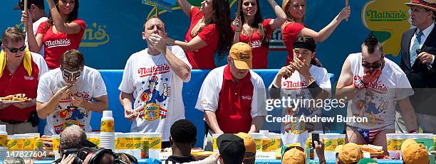 Competitive eaters compete in the men's division of the Nathan's Famous International Hot Dog Eating Contest at Coney Island on July 4, 2012 in the...