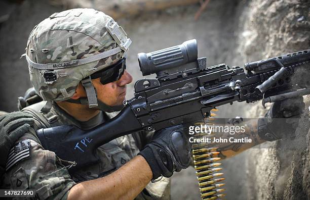 Soldier from 2-12 Infantry Regiment out of Colorado Springs fires a machine gun at insurgent positions during a firefight on June 22, 2012 in the...