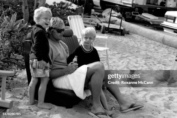 Surfer Laird Hamilton sits with kids on Old Man's beach behind the scenes on the set of a commercial for Nike Aqua Socks in 1990 in San Onofre,...