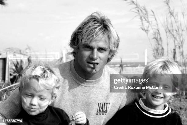 Surfer Laird Hamilton sits with kids on Old Man's beach behind the scenes on the set of a commercial for Nike Aqua Socks in 1990 in San Onofre,...