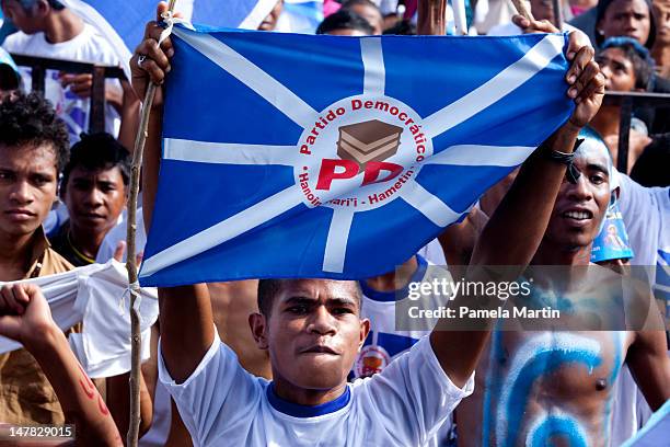 Person holds a flag during the final Democratic Party election rally on July 04, 2012 in Dili, East Timor. Twenty-one political parties are running...