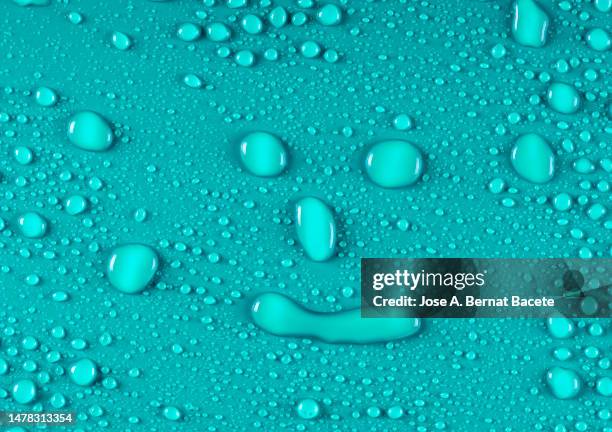 full frame of small water droplets shaped like a human face. - rain face stock pictures, royalty-free photos & images