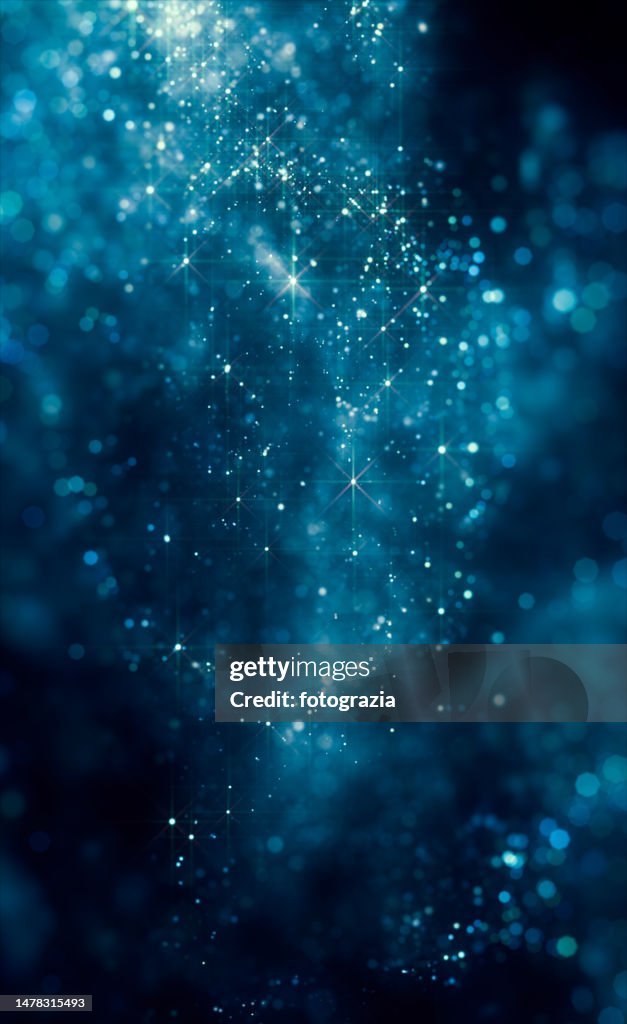 Blue Shiny Defocused Particles against Dark Background