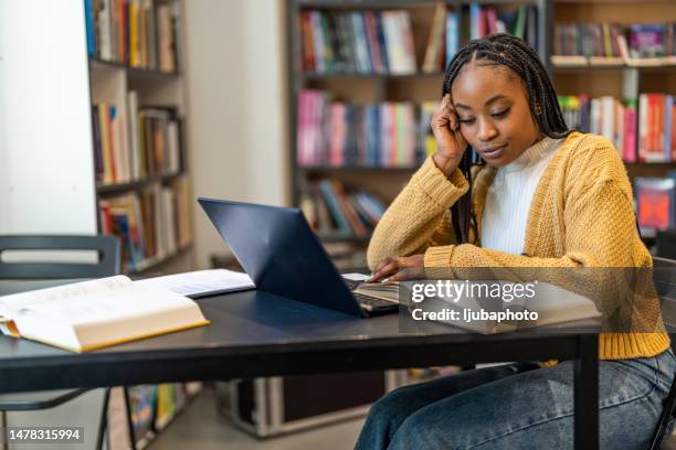 an adult woman studying in the library worried - high tech beauty stockfoto's en -beelden
