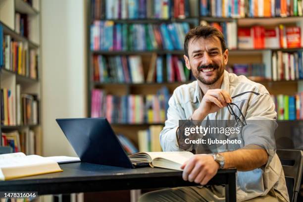 portrait of high school teacher at school library - male author stock pictures, royalty-free photos & images