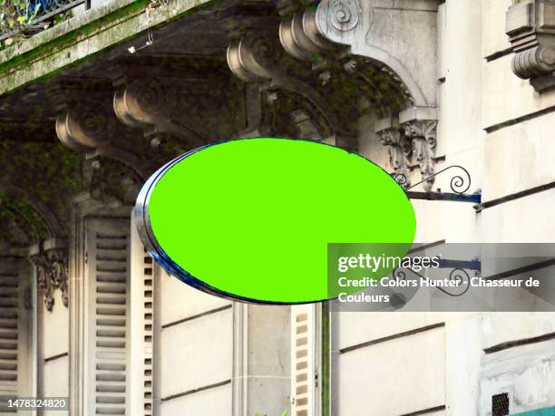 a retro style store sign with green background on the facade of a haussmanian building in paris, france - store sign template stock pictures, royalty-free photos & images
