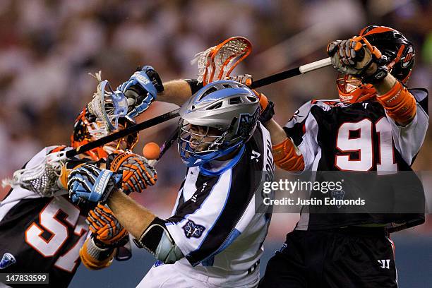 Eric O'Brien of the Ohio Machine has the ball knocked away by Peet Poillon and Dillon Roy of the Denver Outlaws during the fourth quarter at Sports...