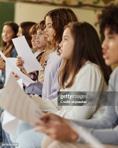 school kids practicing with sheet music on a class at school. - african childrens choir stockfoto's en -beelden