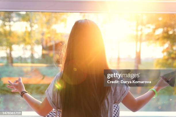 the girl from behind is watching the sunset in the forest in the yoga pose. beautiful nature lifestyle and cute girl with lens flare with copy space. - relaxed sunshine happy lens flare bildbanksfoton och bilder