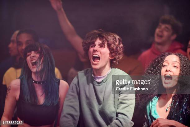 group of people enjoying an evening out at a music venue. - gig stock pictures, royalty-free photos & images