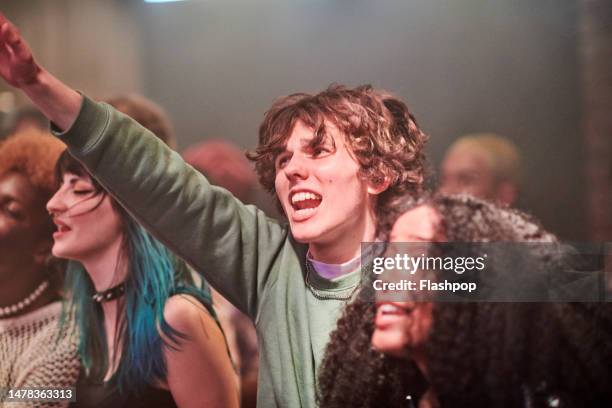 group of people enjoying an evening out at a music venue. - crowd excitement stock pictures, royalty-free photos & images